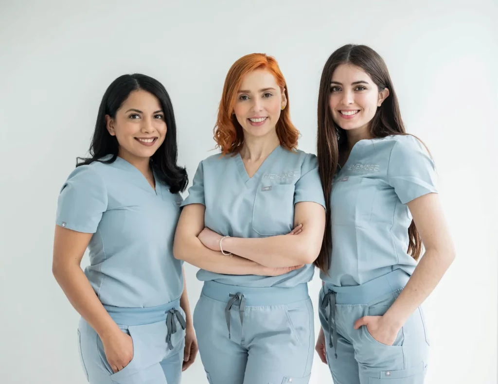 Three women wearing blue scrubs posing for a photo in a LP template.