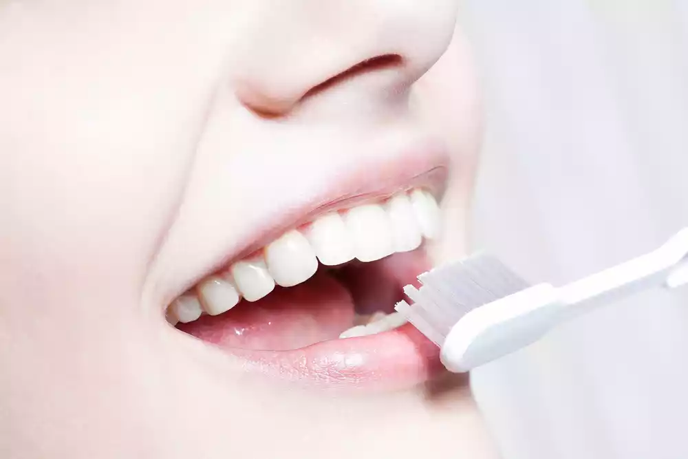 A woman is mastering effective brushing techniques with a toothbrush for a healthier smile.