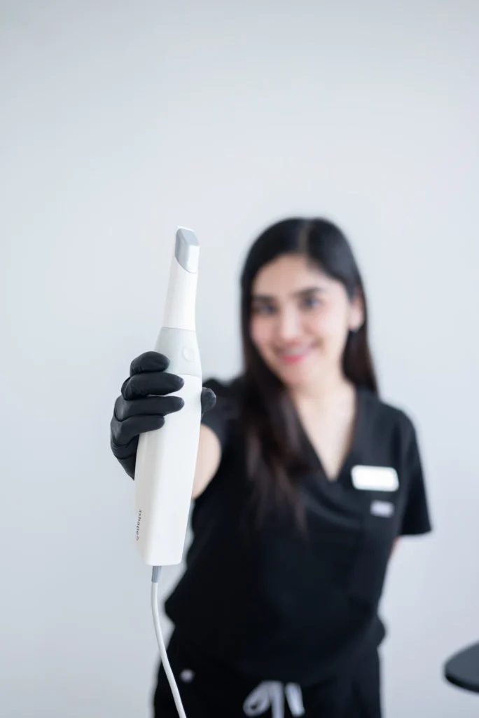 Healthcare professional holding a medical device, with a focus on the instrument.
