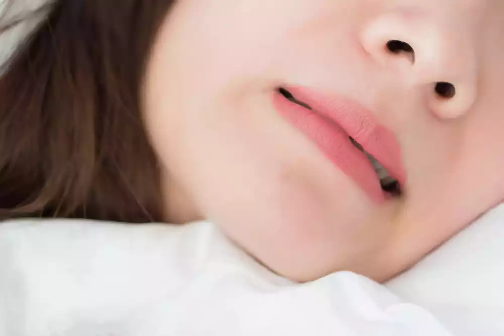 Close-up of a person's lower face, showing lips slightly parted and the tip of the nose, suggesting a moment of rest or contemplation after overcoming teeth grinding.